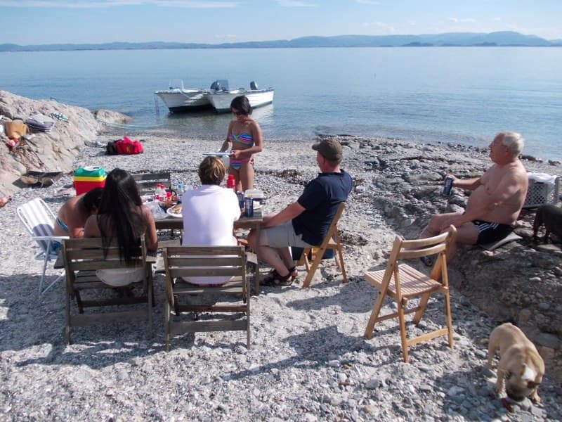 Gäste beim Grillen am Strand vor dem Hafen